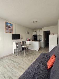 La Fleur de Roseau 200m de la plage 300 m des Commerces في لو غراو دو روا: غرفة نوم بها سرير وطاولة ومطبخ