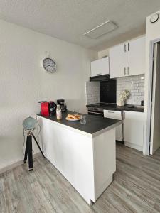 La Fleur de Roseau 200m de la plage 300 m des Commerces في لو غراو دو روا: مطبخ مع كونتر عليه صحن من الطعام