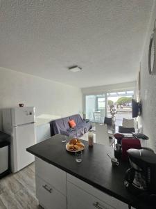 La Fleur de Roseau 200m de la plage 300 m des Commerces في لو غراو دو روا: مطبخ مع طاولة عليها صحن من الطعام +34 صورة