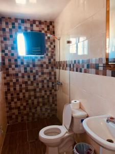 łazienka z toaletą i umywalką w obiekcie Grande y acogedor apartamento cerca de la playa. w mieście Azua de Compostela