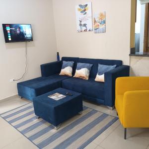 a living room with a blue couch and a table at Grande y acogedor apartamento cerca de la playa. in Azua de Compostela
