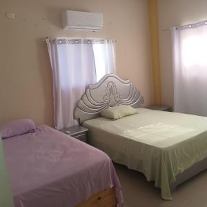 a bedroom with two beds and a window at Grande y acogedor apartamento cerca de la playa. in Azua de Compostela