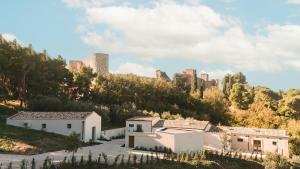 ein Gebäude auf einem Hügel mit einem Schloss im Hintergrund in der Unterkunft Borgo Vinceri in Lucera