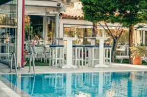 a pool with a table and chairs next to a building at Georgia's Garden by Omilos Hotels in Amoudara Herakliou
