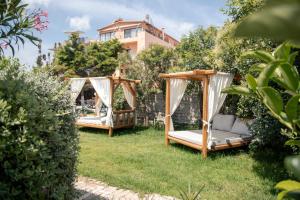 two gazebos sitting in the grass in a yard at Georgia's Garden by Omilos Hotels in Amoudara Herakliou