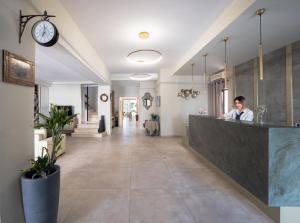 a woman sitting at a counter in a lobby at Georgia's Garden by Omilos Hotels in Amoudara Herakliou