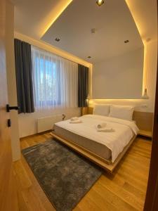 a bedroom with a large bed and a large window at Apart hotel Zlatni Javor - Trio in Jahorina