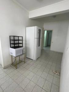kuchnia z lodówką i krzesłem w pokoju w obiekcie Apartamento a 100m. da Praia de Pitangueiras w mieście Guarujá