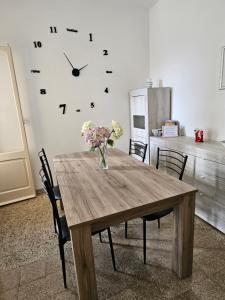 mesa de comedor con reloj en la pared en Casa Marna: comodità e praticità con vista Duomo en Massa Marittima