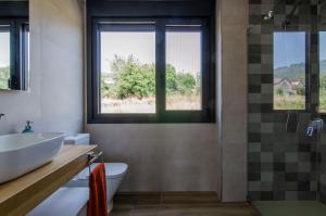 y baño con lavabo y ducha. en Espectacular casa con encanto para familias y grupos, en Ourense