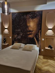 1 dormitorio con 1 cama grande y una pintura en la pared en L'improbable raffiné, élégant et chaleureux, 