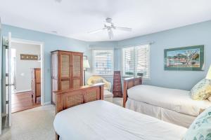 een slaapkamer met 2 bedden en een plafondventilator bij 301I Tidewater in Isle of Palms