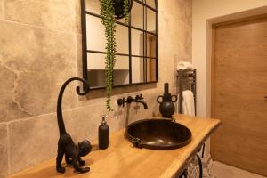 La salle de bains est pourvue d'un lavabo avec une statue de chat noir sur un comptoir. dans l'établissement L'improbable raffiné, élégant et chaleureux, 