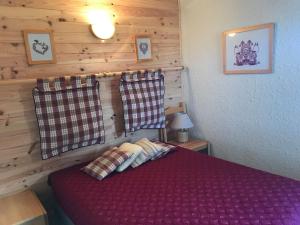 a bedroom with a purple bed in a wooden wall at Appartement Valmorel, 2 pièces, 4 personnes - FR-1-356-181 in Valmorel