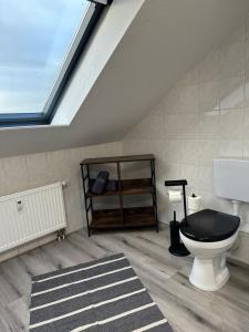 a bathroom with a black toilet and a skylight at Ferienwohnung Zeitz - Weiße Elster Apartment Nr 9 in Zeitz