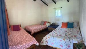 a room with two beds and a window at Finca La Esperanza - Cabaña Villa Marujita in Socorro