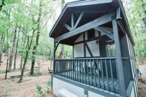 a tree house with a balcony in the woods at Tiny Home Cottage Near the Smokies #10 Helena in Sevierville