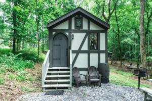 Tiny Home Cottage Near the Smokies #10 Helena في سيفيرفيل: شرفة مع كرسيين وباب