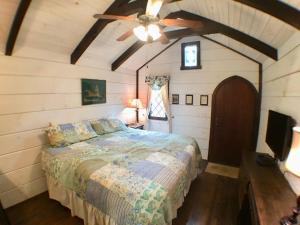 - une chambre avec un lit et un ventilateur de plafond dans l'établissement Tiny Home Cottage Near the Smokies #10 Helena, à Sevierville