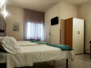 una camera con tre letti e una televisione in esso di Hotel Il Boschetto a Pistoia