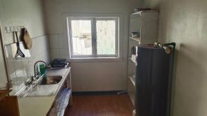 a kitchen with a refrigerator and a window at HOSTAL VALDIVIA in Valdivia