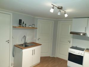 a kitchen with white cabinets and a sink at Trondheim, Kroppanmarka Tiller in Trondheim