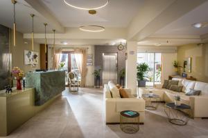 a living room with a couch and a table at Georgia's Garden by Omilos Hotels in Amoudara Herakliou