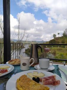 una mesa con dos platos de desayuno. en Cabaña con jacuzzi y acceso al embalse Portum III en El Peñol