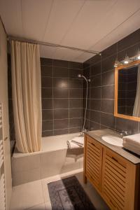 a bathroom with a tub and a sink and a shower at Le Lodge du Cap Ferret in Cap-Ferret