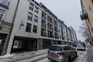 une voiture blanche garée devant un bâtiment dans l'établissement Apartamenty DeLux Centrum Kielce, à Kielce