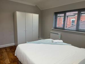 a bedroom with a white bed and a window at Rest Haven Lodge in Kettering