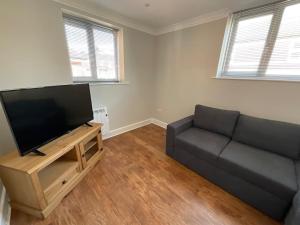 a living room with a couch and a flat screen tv at Rest Haven Lodge in Kettering