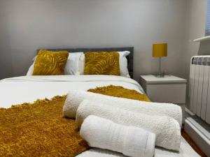 Schlafzimmer mit einem Bett mit weißer Bettwäsche und gelben Kissen in der Unterkunft Rest Haven Lodge in Kettering