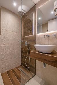 a bathroom with a sink and a glass shower at Mirabel CityCenter Hotel in Argostoli