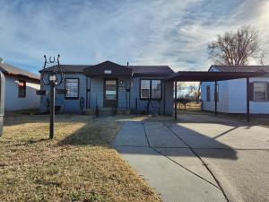 Uma casa branca com um relógio à frente. em Modern Comforts/7minTo Downtown em Oklahoma City