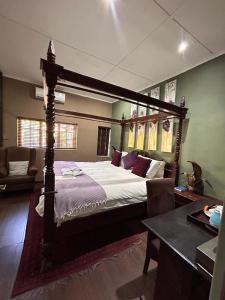 a bedroom with a large bed with a wooden frame at Moonriver Guesthouse in Upington
