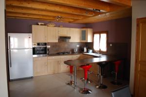 a kitchen with a white refrigerator and red stools at la grange in Wintzenheim