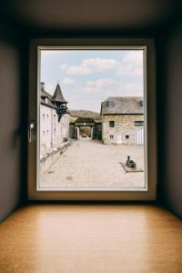 ein Fenster mit Blick auf einen Innenhof außerhalb eines Schlosses in der Unterkunft Hôtel Five Nations in Durbuy