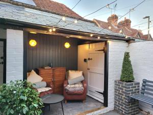 a pergola with two chairs and a table on a patio at The Neptune in Henley on Thames