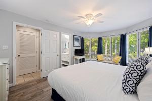 een slaapkamer met een wit bed en een plafondventilator bij 5556 Turtle Cove in Kiawah Island