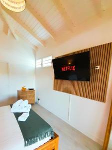 um quarto com um sinal de netflix numa parede em Studio Karaïbes em Sainte-Anne