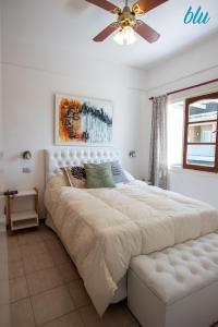 Un dormitorio con una cama grande blanca con ventilador de techo. en BLU Apart, en Ostende