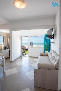 Una sala de estar con un sofá y vista al mar. en BLU Apart, en Ostende