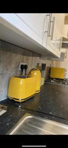 two yellow containers sitting on a counter in a kitchen at St James House - Sleeps 8! in Leeds