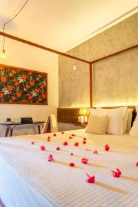 a bedroom with a bed with red flowers on it at Casa Valentini Pousada in Jericoacoara