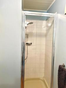 a shower with a glass door in a bathroom at The Cotswolds Lakeside - Kinsale Lodge,Spring Lake in South Cerney