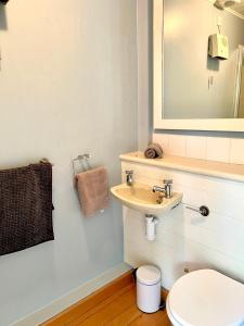 a bathroom with a sink and a toilet and a mirror at The Cotswolds Lakeside - Kinsale Lodge,Spring Lake in South Cerney