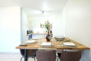 a kitchen with a wooden table with chairs at Chaleureux T3 Beauregard in Annecy