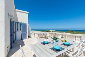 einen Tisch und Stühle auf einem Balkon mit Meerblick in der Unterkunft Casa D'Amare in Ostuni Costa Merlata