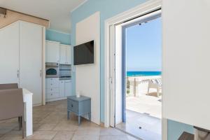 une cuisine avec une porte coulissante en verre offrant une vue sur l'océan. dans l'établissement Casa D'Amare, à Ostuni Costa Merlata